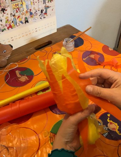 Unsere halbe Plastikflasche wird mit gelben und orangen Flammen beklebt.